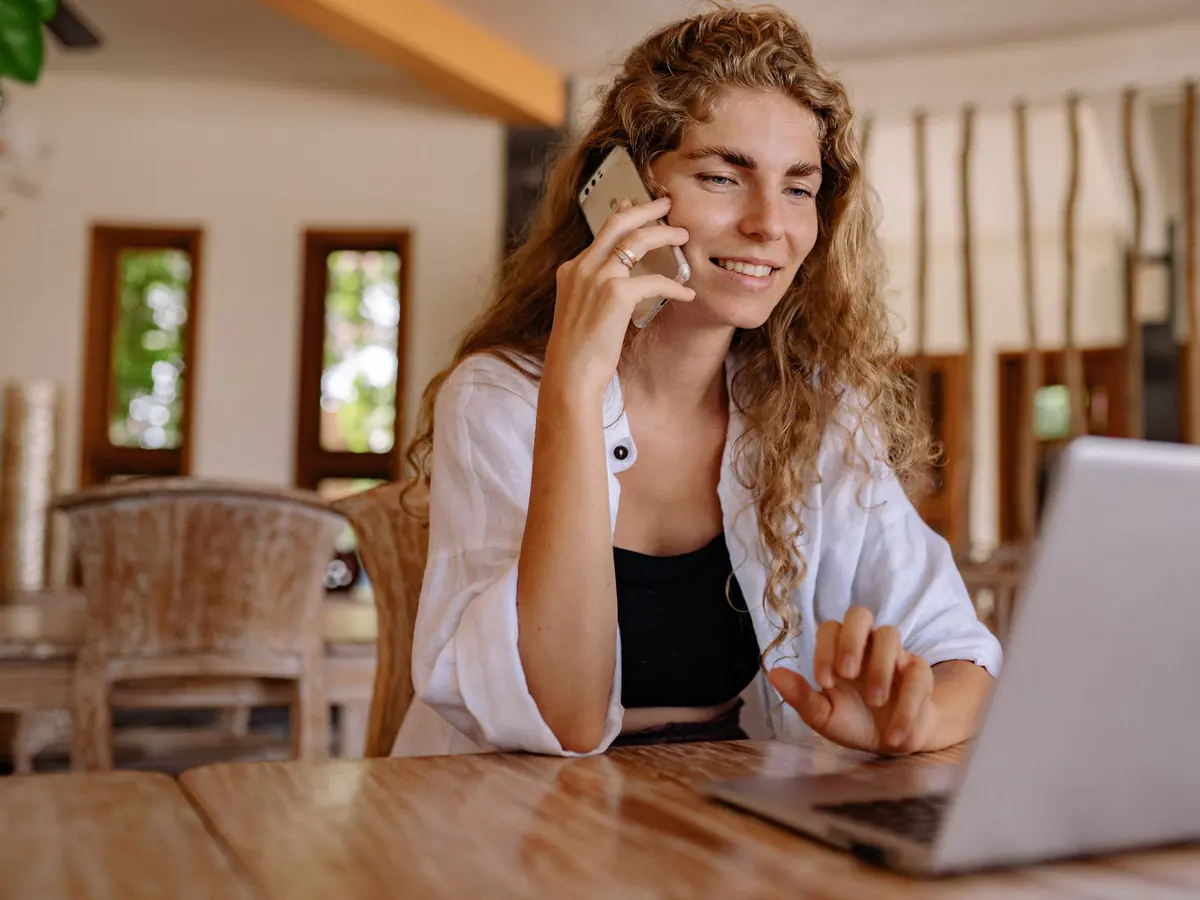 Smiling homeowner on a phone call at her kitchen table