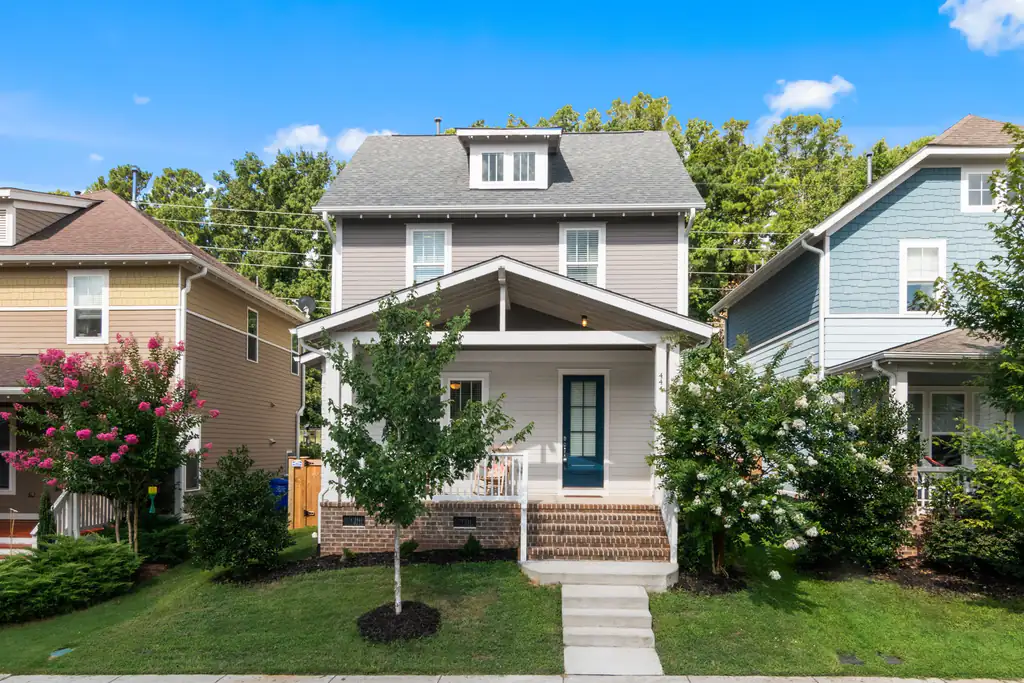 Two-story family house with a front porch and a green lawn